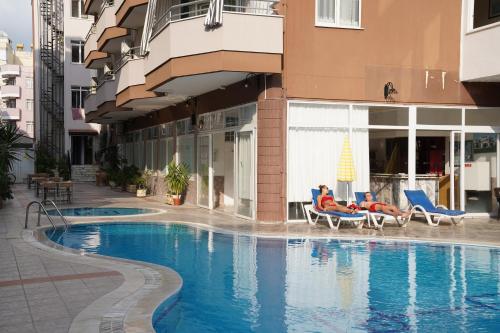 アランヤにあるPolat tatil evleriのホテルのスイミングプールの隣に椅子を用意しています。