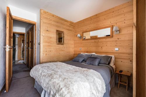 a bedroom with a bed in a wooden wall at Luxury Avoriaz Chalet with hot tub in Avoriaz