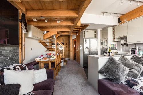 eine Küche und ein Wohnzimmer mit Sofas und einem Tisch in der Unterkunft Luxury Avoriaz Chalet with hot tub in Avoriaz