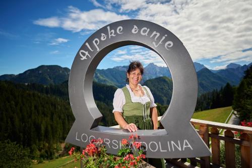 a woman standing in a sign in the mountains at Shepherds House "Alpine Dreams" in Solčava