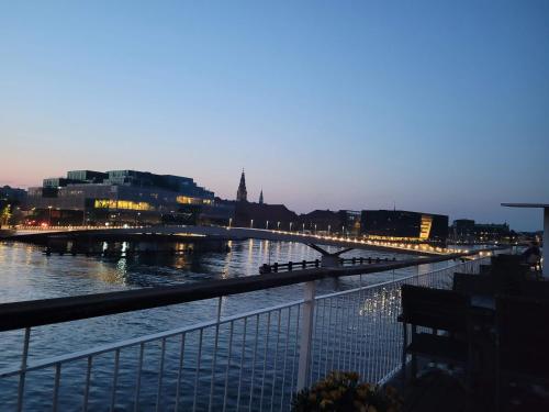 a bridge over a river with a city at night at Hotel CPH Living in Copenhagen