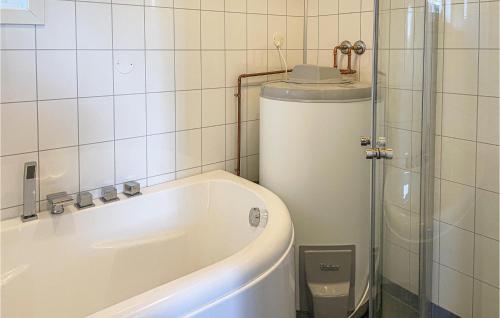 a small bathroom with a tub and a toilet at Beautiful Home In Kvam With 3 Bedrooms in Kvam