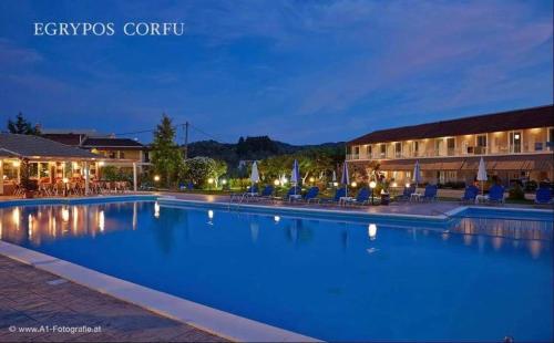 a large swimming pool in front of a hotel at Egrypos Hotel in Petrití