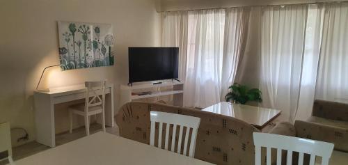 a living room with a television and a table and chairs at Beautiful inner city fully renovated ground floor apartment with attached lock-up garage in Canberra
