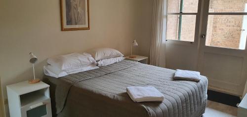 um quarto com uma cama com duas toalhas em Beautiful inner city fully renovated ground floor apartment with attached lock-up garage em Camberra