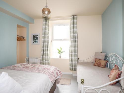 sypialnia z 2 łóżkami i oknem w obiekcie Gadlys House 62 w mieście Beaumaris