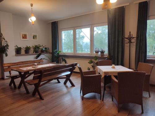 a dining room with tables and chairs and windows at Motel Strzeszynek in Poznań