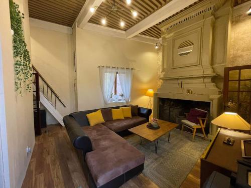 sala de estar con sofá y chimenea en "Maison du consul" avec terrasse - centre historique en Narbonne