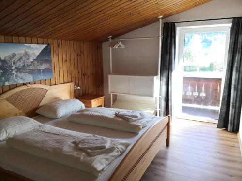 a bedroom with two beds and a large window at Alpen Chalet Bramberg in Bramberg am Wildkogel