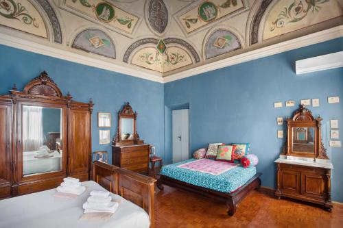 een blauwe slaapkamer met een bed en een spiegel bij Villa Oleandra with Pool up to 12 People in Volta Mantovana