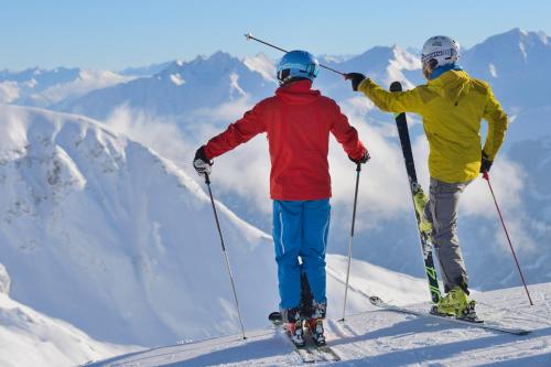 two people standing on top of a snow covered mountain at Hotel Garni Central - Zimmer - Studios - Apartments in Kappl