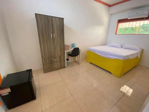 a bedroom with a bed and a desk and a window at Scott's Seaview Resort in Danao City