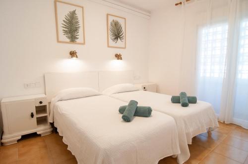 1 dormitorio con 2 camas y toallas. en Seafront L'Estartit Apartments, en L'Estartit