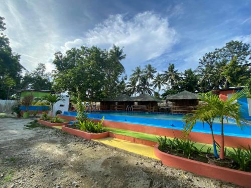 un complexe avec une grande piscine bordée de palmiers dans l'établissement Scott's Seaview Resort, à Idanao