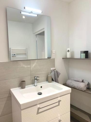 une salle de bain avec un lavabo blanc et un miroir dans l'établissement Esprit Cosy au centre historique, à Toulon