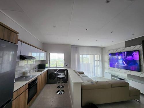 a kitchen with a couch and a large screen tv at Ballito Hills Lifestyle Estate Unit 423 in Ballito