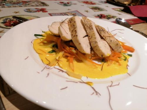 a plate of food with chicken and carrots on it at Adler Hotel-Pension in Fulpmes