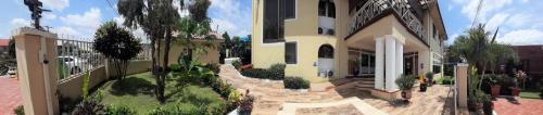 a large house with a garden in front of it at Asantewaa Premier Hotel in Kumasi
