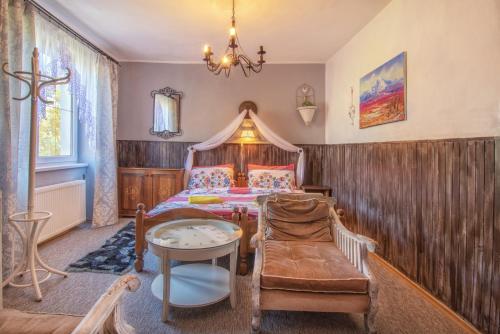 a bedroom with a bed and a table and a chair at Penzion Šilon in Ždiar