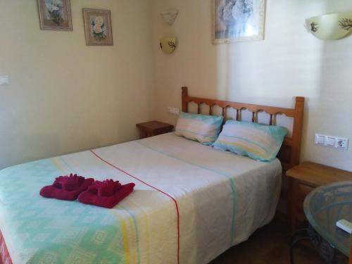 ein Schlafzimmer mit einem Bett mit zwei roten Handtüchern darauf in der Unterkunft Encantador adosado en Gran Alacant in Gran Alacant