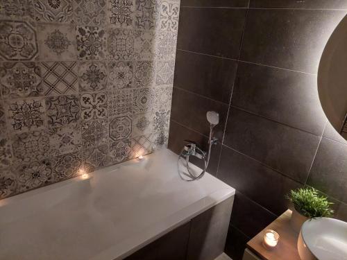 W łazience znajduje się wanna, umywalka i oświetlenie. w obiekcie Harmony Residence One WITH JACUZZI w Pradze