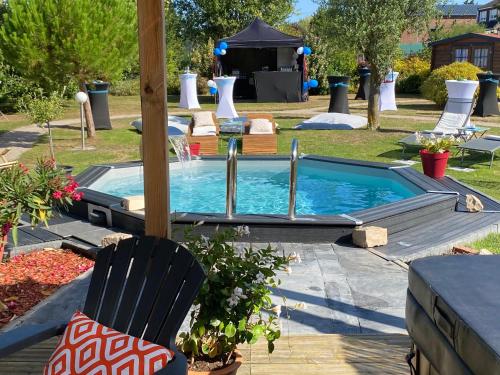 a swimming pool with a table and a chair and a table at Au Domaine Fresnois in Fresnes-lès-Montauban