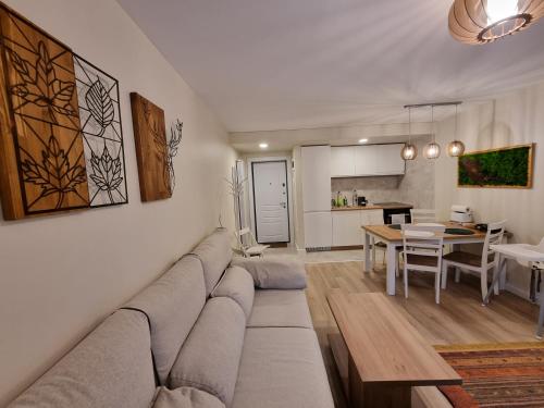 uma sala de estar com um sofá e uma sala de jantar em Eminescu Premium Luxury Apartments em Buşteni