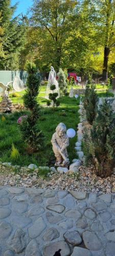 une statue d'un chien tenant un frisbee dans un jardin dans l'établissement Tiny Dream House, à Buşteni