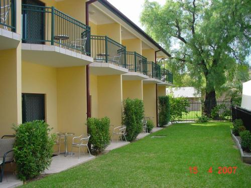 a building with chairs and a lawn in front of it at St Marys Park View Motel in St Marys