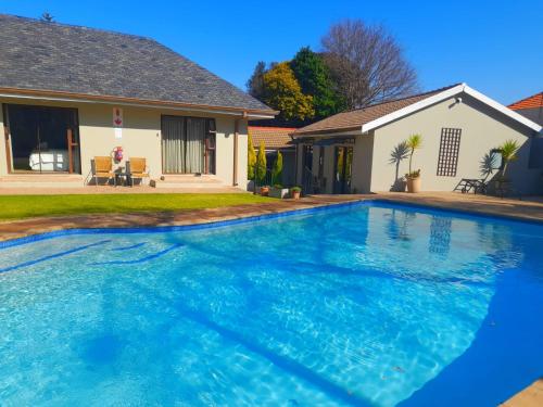 a large blue swimming pool in front of a house at 47 On Preston Guesthouse in Johannesburg