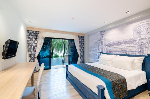 a hotel room with a bed and a tv at Bhukitta Boutique Hotel Phuket Town in Phuket Town