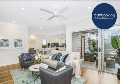 a living room with a couch and a ceiling fan at Park Ave Retreat - 3 Carparks, WiFi, BBQ, King Bed in Brisbane