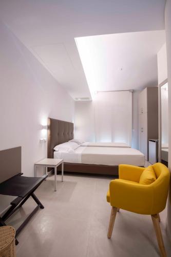 a bedroom with a bed and a yellow chair at B&B Contessa in Gubbio