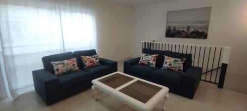 a living room with two couches and a coffee table at Piso en el Centro de La Cala in Mijas Costa