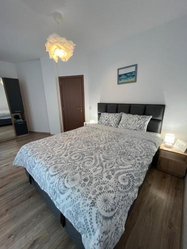 um quarto com uma cama com uma colcha azul e branca em Azzurro Premium Apartment on Bulevard Bogoridi em Burgas