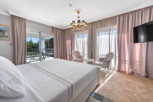 1 Schlafzimmer mit einem großen weißen Bett und einem Esszimmer in der Unterkunft Villa Carolus-Luxurious Dalmatia Villa in Vodice