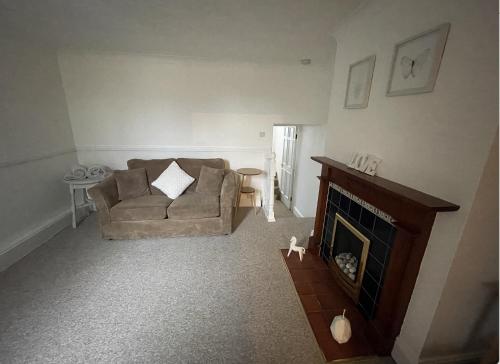 a living room with a couch and a fireplace at Amaya Two - Spacious, ground floor apartment with a large patio area. in Lincolnshire