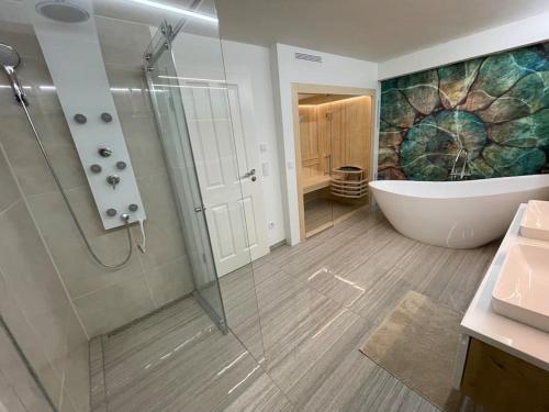 a bathroom with a shower and a tub and a sink at Luxuriöses Loft mit großer Sonnenterrasse & Sauna in Munich