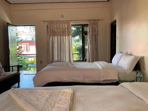 una camera da letto con due letti e una finestra di Trekkers Lodge a Pokhara
