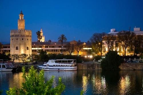un barco blanco en el agua frente a un edificio en Spalis Suite Loft de lujo en el centro histórico, en Sevilla