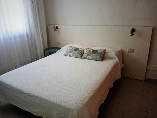 a bedroom with a white bed with two pillows on it at Apartamento en Puerto Rico in Puerto Rico de Gran Canaria