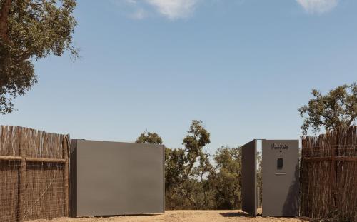 two refrigerators are standing in front of a fence at Pa.te.os in Melides