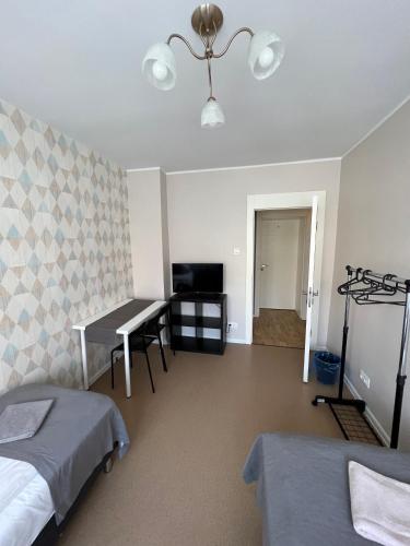 1 dormitorio con 2 camas, escritorio y TV en Abra IV Apartament, en Poznan