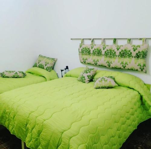 a bedroom with two beds with lime green comforter at Il Quadrifoglio di Triveri in Bovalino Marina