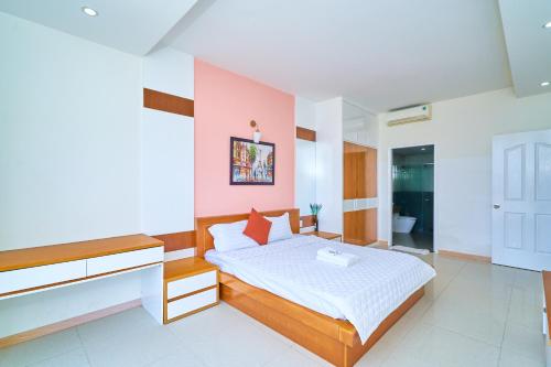 ein Schlafzimmer mit einem Bett und einer rosa Wand in der Unterkunft Pooh House 6 - Back Beach apartment in Vũng Tàu