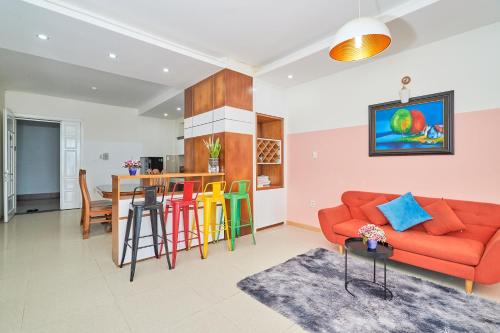 ein Wohnzimmer mit einem roten Sofa und bunten Hockern in der Unterkunft Pooh House 6 - Back Beach apartment in Vũng Tàu