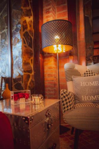 a room with a table and a lamp and a chair at Hunter Vip in Reghin