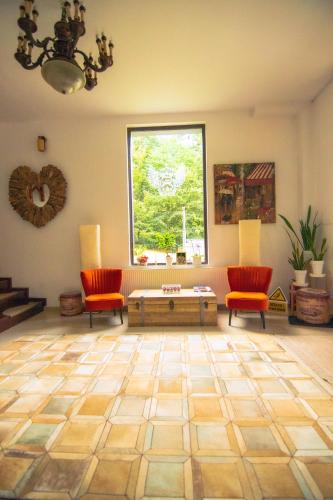 a living room with two chairs and a table and a window at Hunter Vip in Reghin