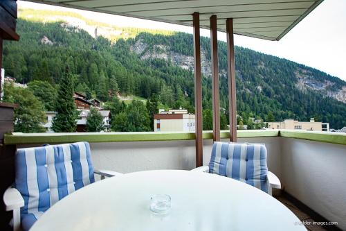 a white table and chairs on a balcony with a mountain at Hotel Astoria in Leukerbad