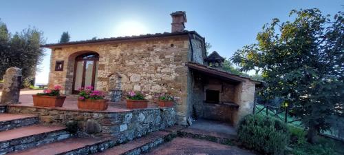 a stone house with potted plants on a stone wall at Agriturismo La Scarpaia in Anghiari